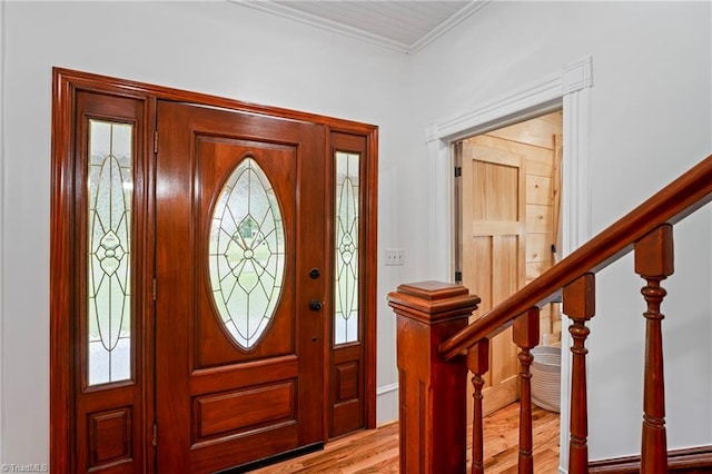 entrance foyer with ornamental molding and light hardwood / wood-style flooring