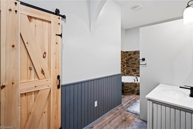 bathroom featuring a tub, hardwood / wood-style floors, and vanity