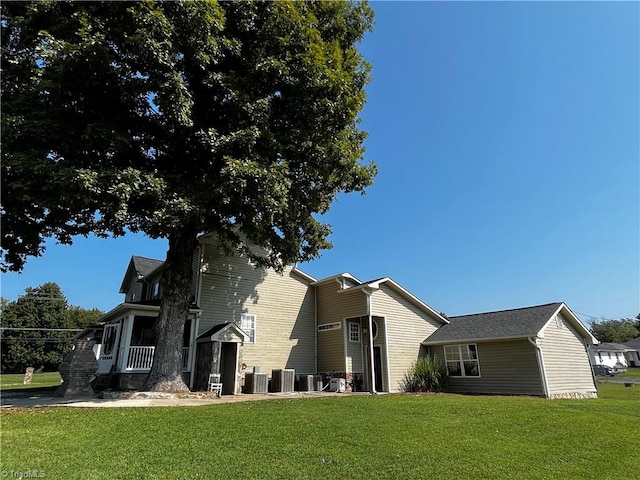 view of property exterior with central AC unit and a lawn