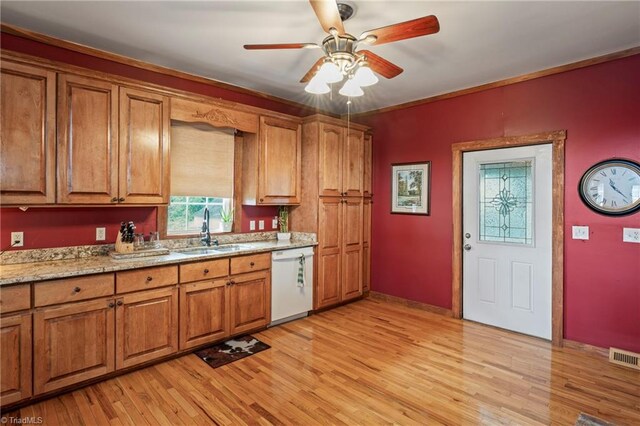 kitchen with white dishwasher, light hardwood / wood-style flooring, ceiling fan, and sink