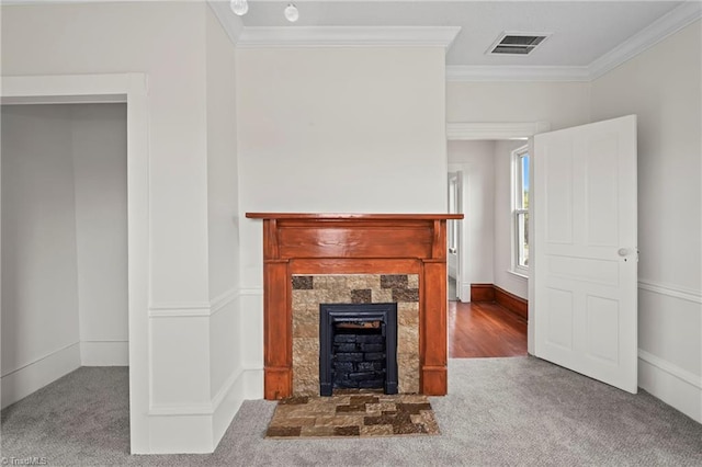 unfurnished living room featuring a tiled fireplace, crown molding, and carpet floors