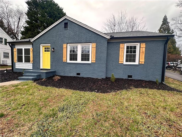 view of front facade with a front yard, roof with shingles, and crawl space