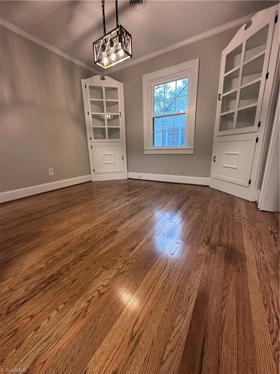 1214 Fillman Dr, Reidsville, NC 27320 - unfurnished dining area featuring baseboards, dark wood-type flooring, and crown molding
