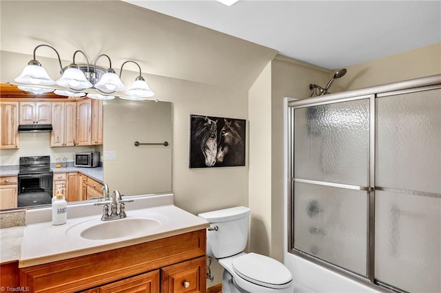 bathroom with vanity, enclosed tub / shower combo, and toilet