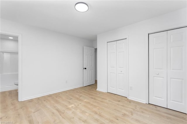 2282 Valewood Dr, Asheboro, NC 27205 - unfurnished bedroom featuring two closets, light wood-style floors, and connected bathroom