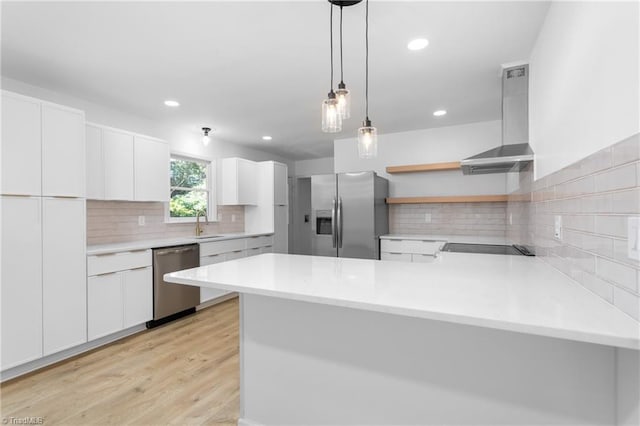 2282 Valewood Dr, Asheboro, NC 27205 - kitchen with stainless steel appliances, wall chimney exhaust hood, a peninsula, tasteful backsplash, and hanging light fixtures