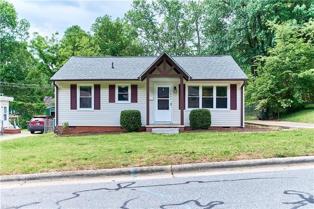 single story home featuring crawl space, a front yard, and a shingled roof