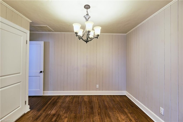 unfurnished room with baseboards, dark wood-style flooring, a chandelier, and ornamental molding