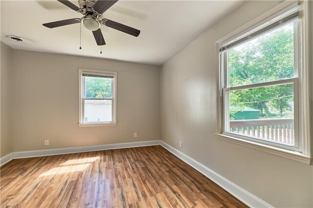 unfurnished room featuring wood finished floors, baseboards, and a ceiling fan