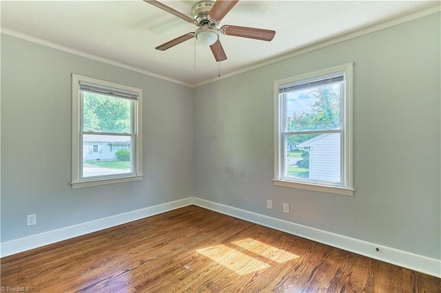 empty room featuring crown molding, baseboards, dark wood finished floors, and a ceiling fan
