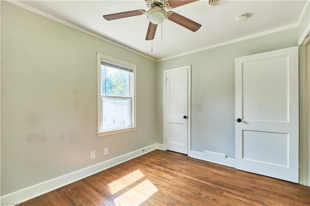 unfurnished bedroom featuring ornamental molding, wood finished floors, baseboards, and ceiling fan