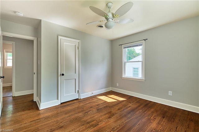 unfurnished bedroom with dark wood-style floors, baseboards, and ceiling fan