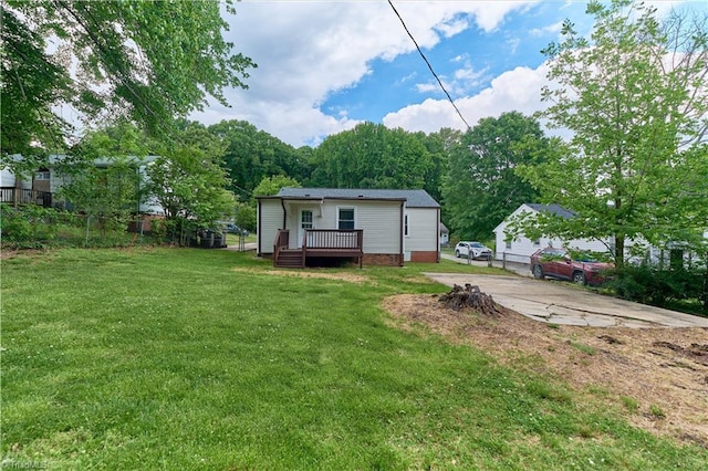 back of property with a wooden deck and concrete driveway
