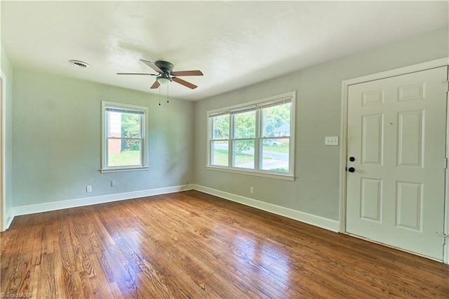 unfurnished room featuring ceiling fan, wood finished floors, and baseboards