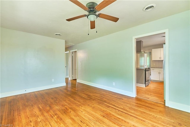 unfurnished room featuring light wood-style flooring, baseboards, and ceiling fan