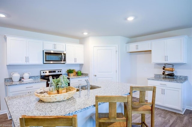 kitchen featuring sink, white cabinetry, stainless steel appliances, and hardwood / wood-style flooring