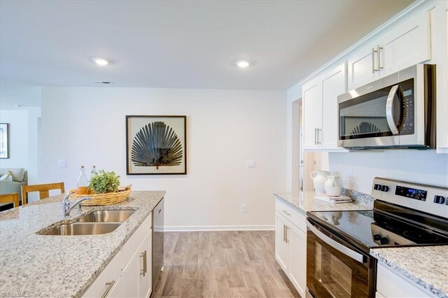 kitchen featuring sink, light hardwood / wood-style flooring, stainless steel appliances, and white cabinets