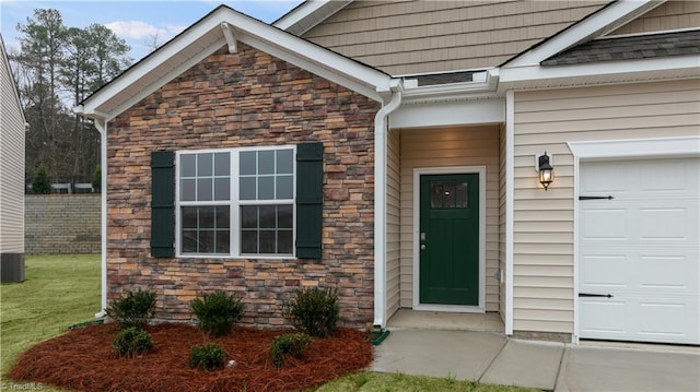 doorway to property featuring a yard and a garage