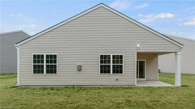 back of property with a yard and a patio area