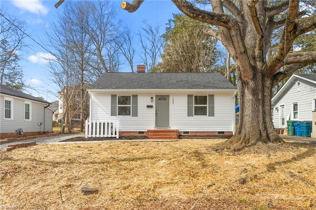 view of front of house featuring crawl space, a front lawn, a chimney, and roof with shingles