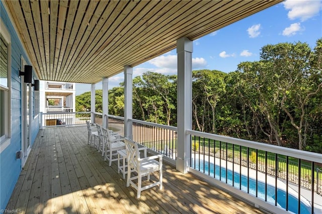 wooden terrace with a fenced in pool