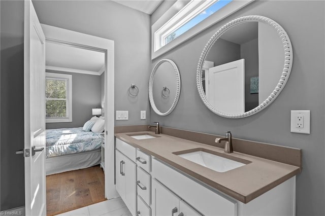 bathroom featuring hardwood / wood-style flooring, double sink vanity, and crown molding