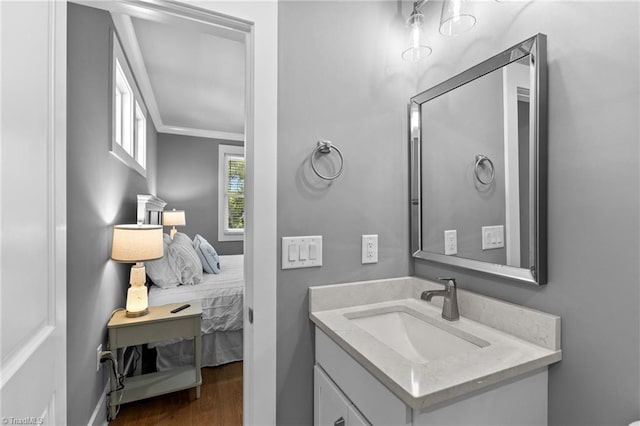 bathroom featuring vanity, hardwood / wood-style flooring, and crown molding