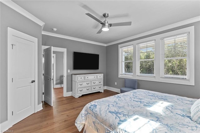 bedroom with crown molding, ceiling fan, and hardwood / wood-style floors