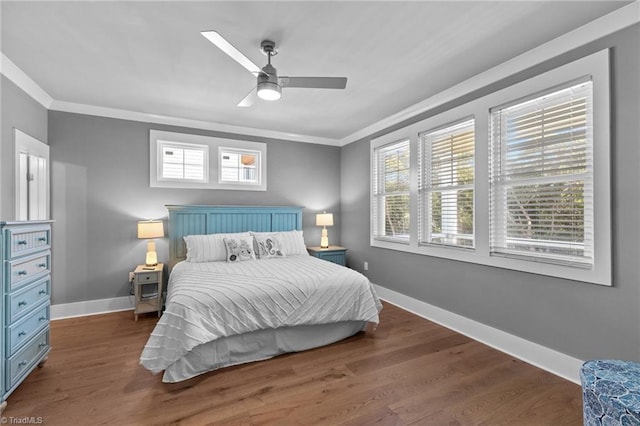 bedroom featuring crown molding, ceiling fan, dark hardwood / wood-style floors, and multiple windows