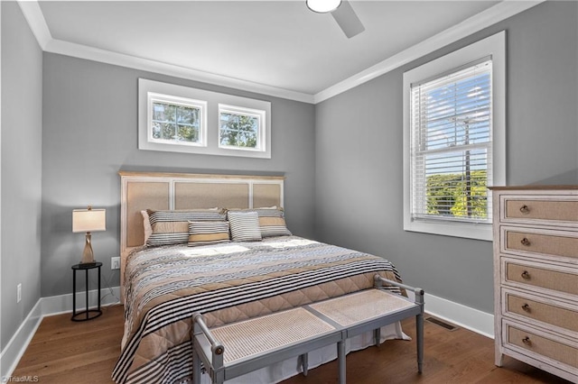 bedroom featuring dark wood-type flooring, ornamental molding, and ceiling fan