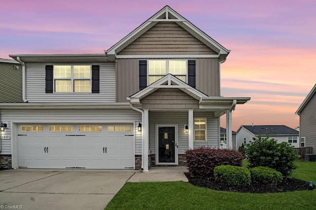 1881 Huntley Way, Burlington, NC 27215 - view of front of home featuring an attached garage, driveway, stone siding, and covered porch