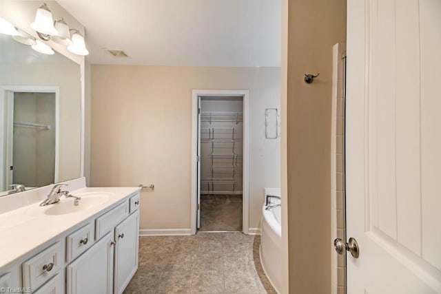 1881 Huntley Way, Burlington, NC 27215 - bathroom with vanity, a spacious closet, a bath, and baseboards