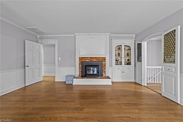 unfurnished living room featuring hardwood / wood-style flooring, ornamental molding, and a fireplace