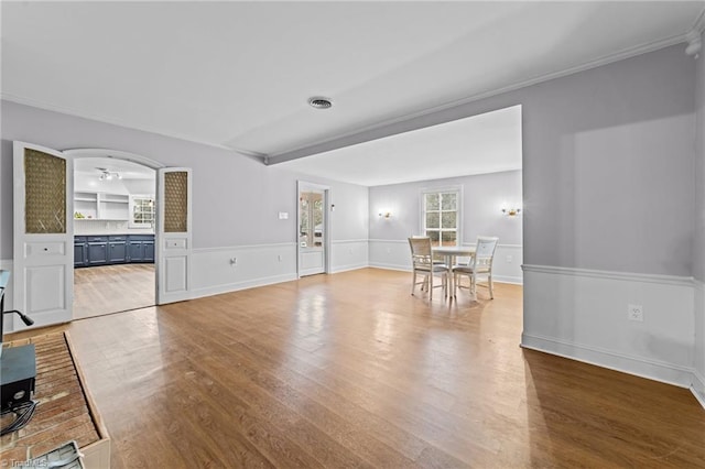 unfurnished living room featuring crown molding and hardwood / wood-style flooring