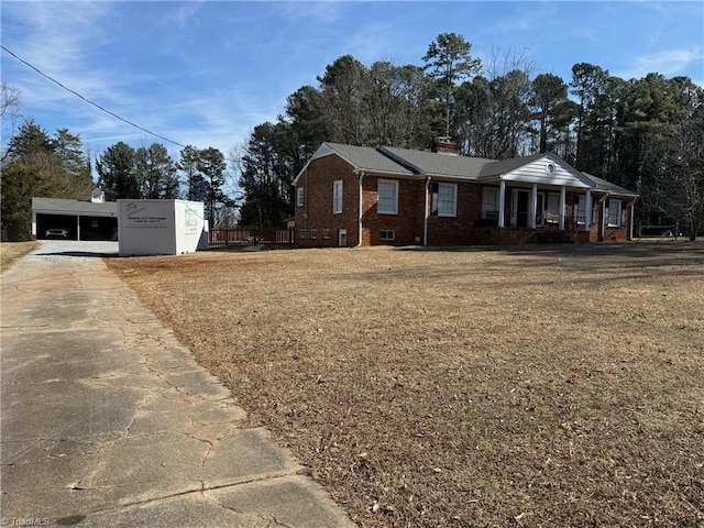 ranch-style home with a carport, covered porch, and a front lawn