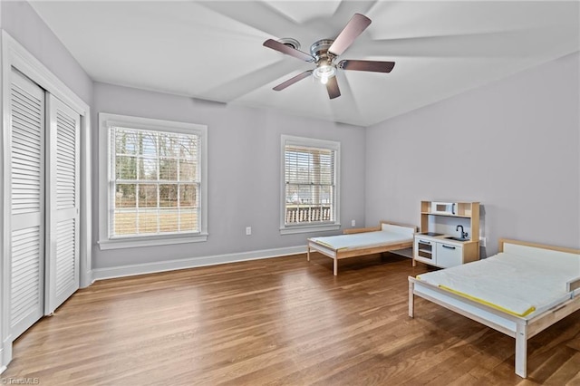 bedroom featuring ceiling fan, a closet, and light wood-type flooring