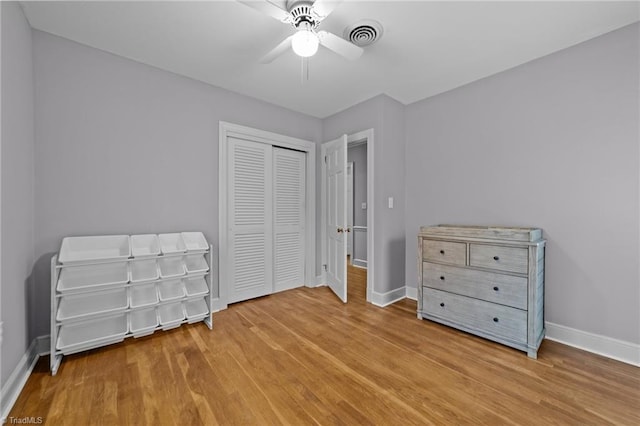 unfurnished bedroom featuring wood-type flooring, ceiling fan, and a closet