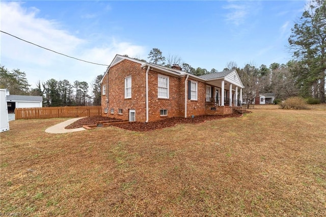 view of side of home featuring covered porch and a lawn