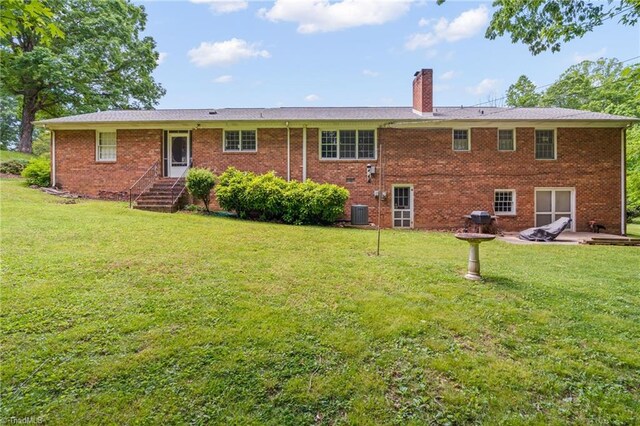 938 Croyden St, High Point, NC 27262 - back of property with a chimney, a lawn, cooling unit, and brick siding