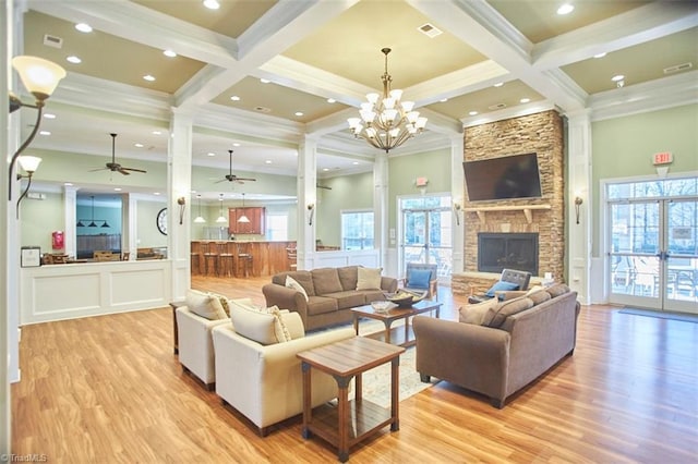 living room featuring visible vents, beam ceiling, crown molding, and light wood finished floors