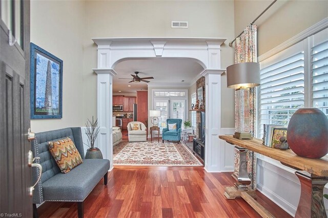 foyer featuring a towering ceiling, visible vents, and ornate columns