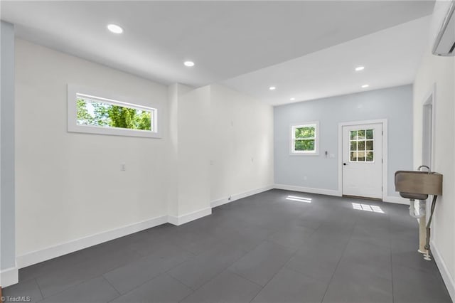 225 Main St E, Pilot Mountain, NC 27041 - unfurnished room featuring an AC wall unit, plenty of natural light, recessed lighting, and baseboards