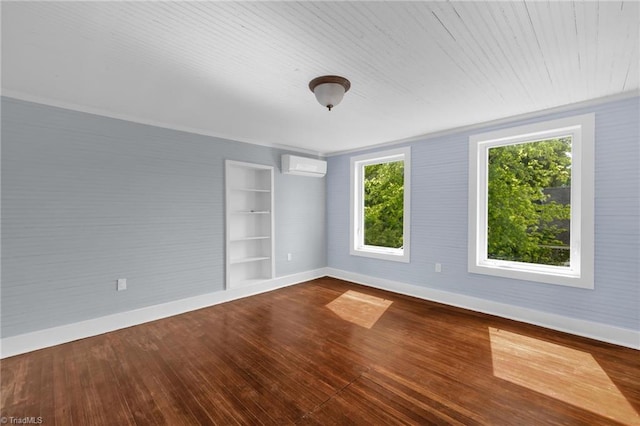 225 Main St E, Pilot Mountain, NC 27041 - empty room with baseboards, a wall unit AC, hardwood / wood-style floors, and built in shelves