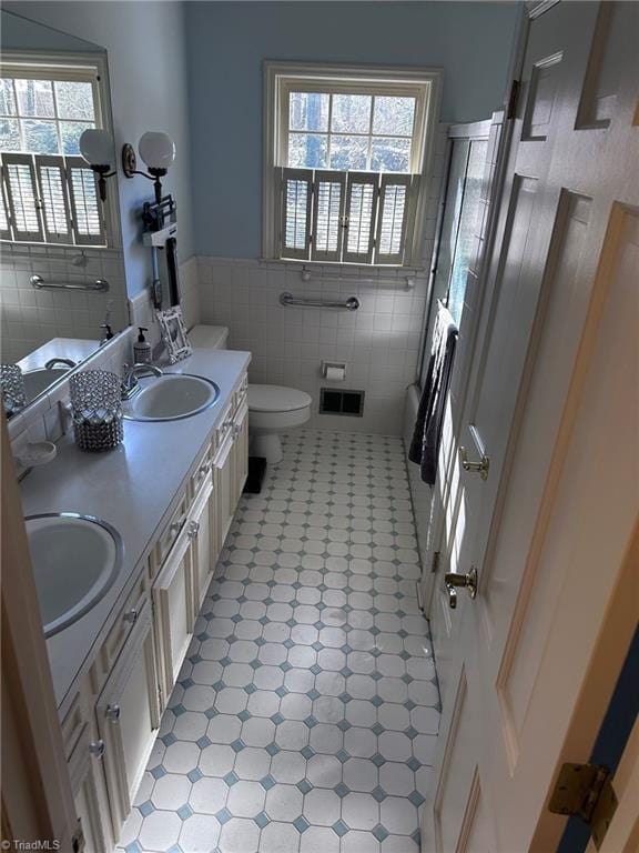 bathroom with plenty of natural light, tile walls, and vanity