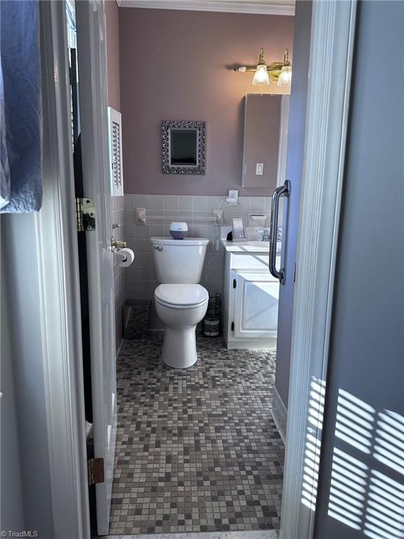 bathroom featuring tile patterned flooring, toilet, and tile walls