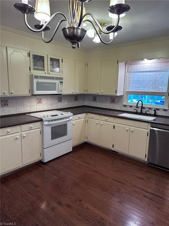 kitchen featuring white appliances, crown molding, dark wood-type flooring, sink, and a notable chandelier