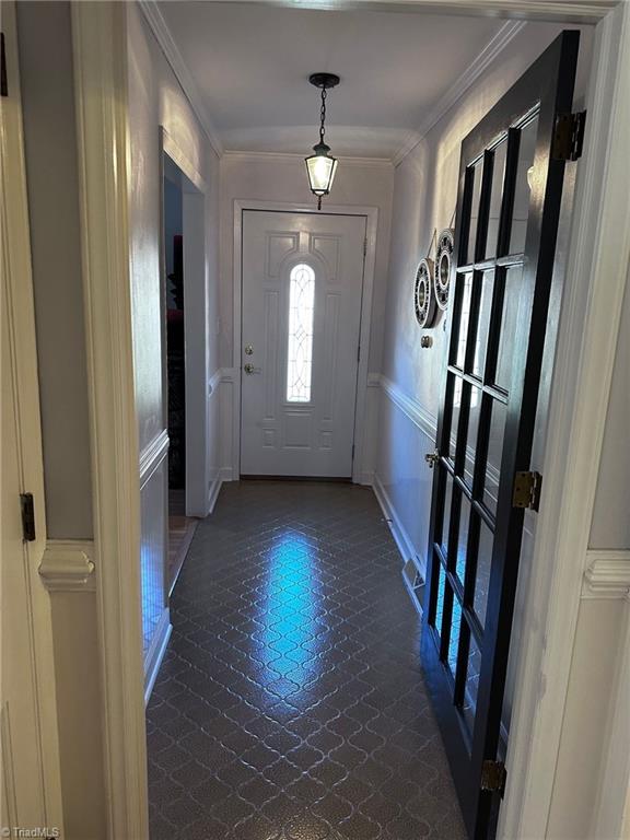 foyer entrance featuring crown molding