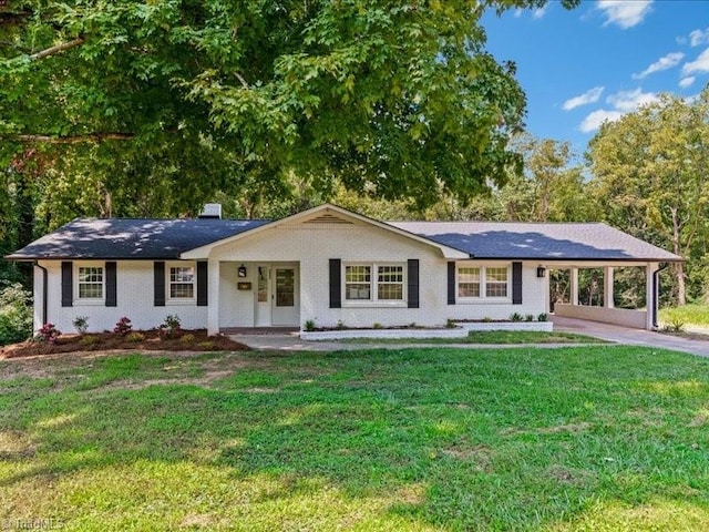 ranch-style home featuring brick siding, driveway, a carport, a front lawn, and a chimney