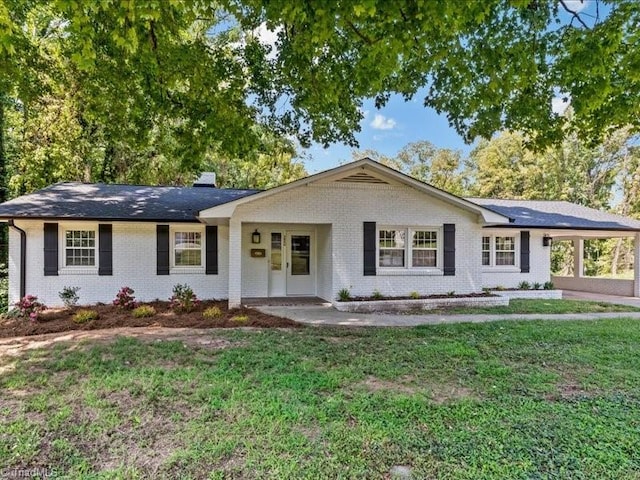 single story home featuring brick siding, a chimney, and a front yard