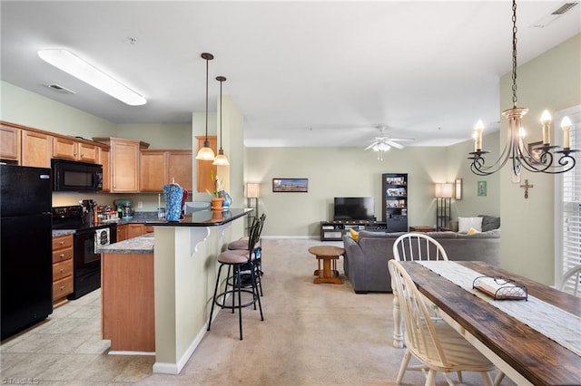 5430 Forester Dr, High Point, NC 27265 - kitchen with black appliances, a breakfast bar, pendant lighting, a peninsula, and a ceiling fan